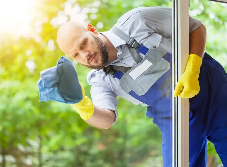 Professional window cleaners using tools to clean high-rise windows.